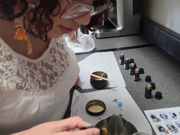 A person adding fragrance oil to candle wax.