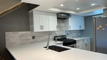 Renovated Poway kitchen with white cabinets, light countertops and tile backsplash.