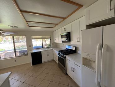 Restored Indian Wells,with white shaker cabinets, light countertops and existing tile flooring.