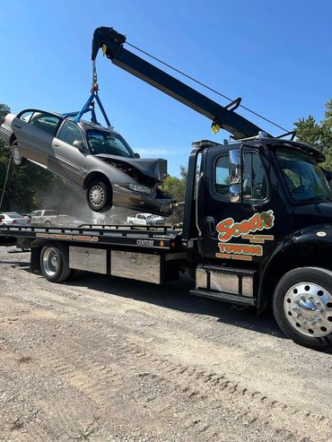 Scott’s Towing operator lifting a vehicle onto flatbed truck during roadside recovery near Hannibal
