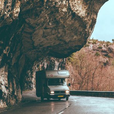 RV driving under cliff