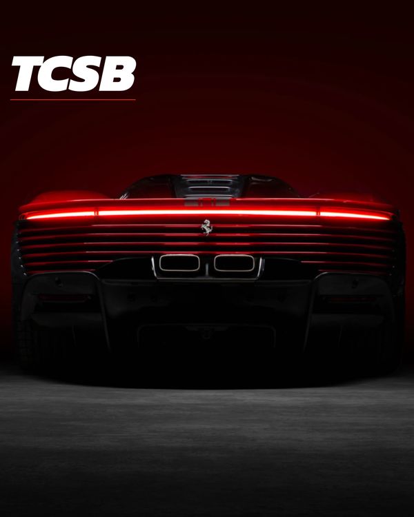 Rear view of a sleek Ferrari with glowing red tail lights.