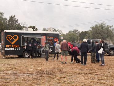 long line of people happily waiting for pit love bbq catering event
