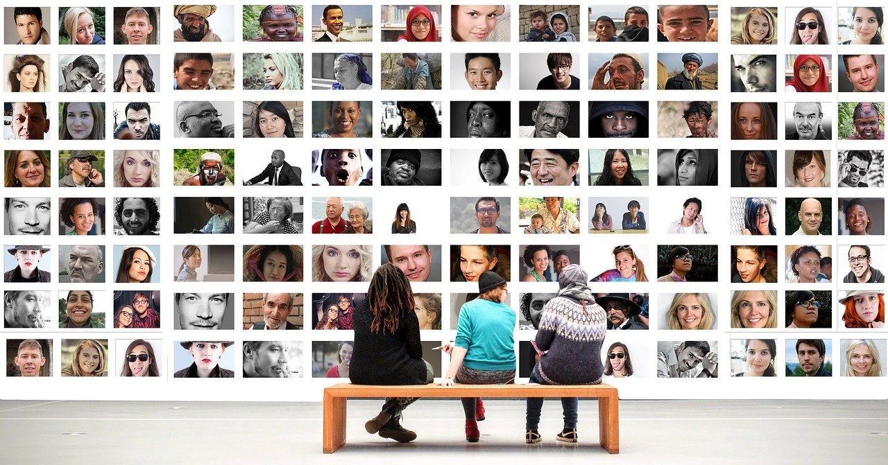 Three people sitting on a bench looking at a photo wall of many diverse people
Counseling
