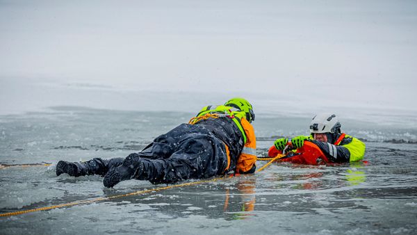 Deux sauveteurs sur glace en actions sur un plan d'eau glacé.