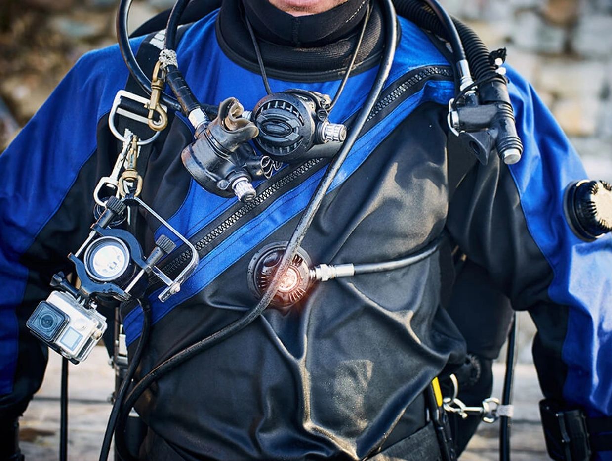 Plongeur en combinaison étanche prêt à faire son entrée dans l'eau.