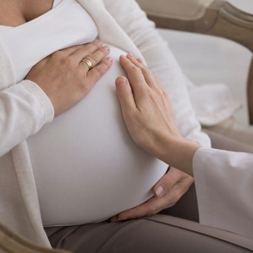 Pregnant woman, doula hand supporting