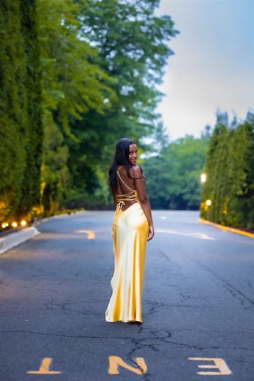 Woman in a gold dress standing on a road.NYC Graduation & Prom Photographer | Taisha Marie Photos