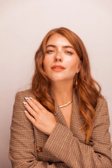 Confident woman with red hair wearing a checkered blazer.NYC Headshot & Branding Photographer | Taisha Marie Photos