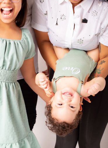 A baby being held upside down playfully.