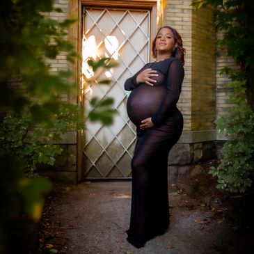 Pregnant woman posing outdoors in a sheer black dress. NYC Maternity Photography Pricing | Taisha Marie Photos