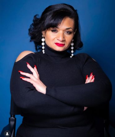 Confident woman in black sweater posing with arms crossed.NYC Headshot & Branding Photographer | Taisha Marie Photos
