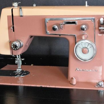 Vintage pink and beige Kenmore sewing machine with retro design.