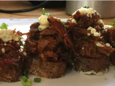 Baked potato slices topped with slow roasted BBQ pork, blue cheese crumbles, and chives.