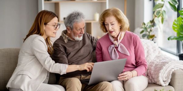 Three people looking at a laptop together.