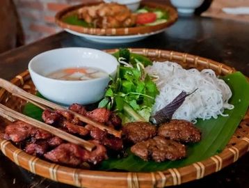 Grilled pork and crispy spring rolls over vermicelli with herbs, peanuts, and fish sauce.