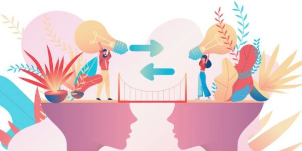 Two people exchange ideas represented by light bulbs across a bridge connecting two heads.