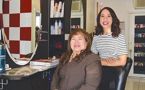  Founders, Rosa Salmeron (sitting, Left) and Janet Salmeron (standing, right) posing for a photo at The Cherry Blossom Hair Studio