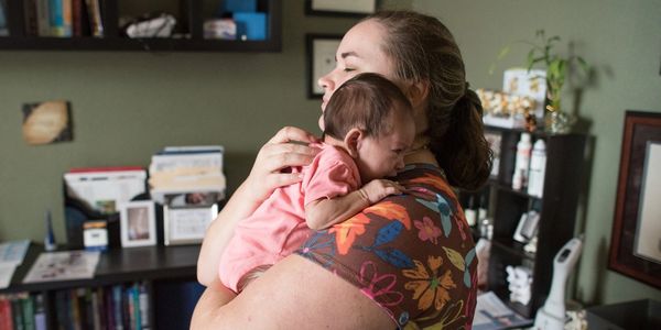Dr. Gardner is holding an infant.