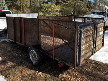 The trailer is 6 ft long, with 4 ft walls. Hold Approximately 4 Yards of trash.