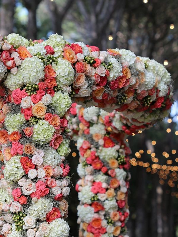 Two floral arches with various colored roses and hydrangeas.