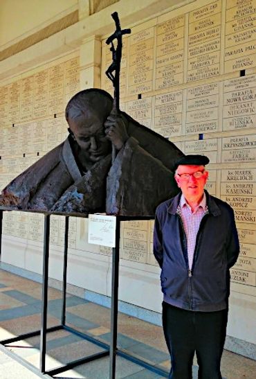 Terry standing next to the bronze bust of John Paul II outside the JP II Centre, Krakow.