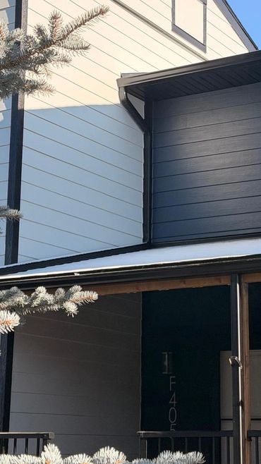 Modern two-tone house exterior with clear blue sky.