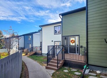 Modern townhouses with neat porches and a clear blue sky.