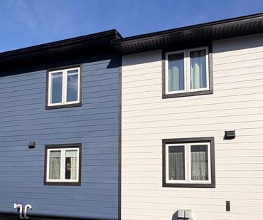 Two-tone house exterior with blue and white siding and white-framed windows.