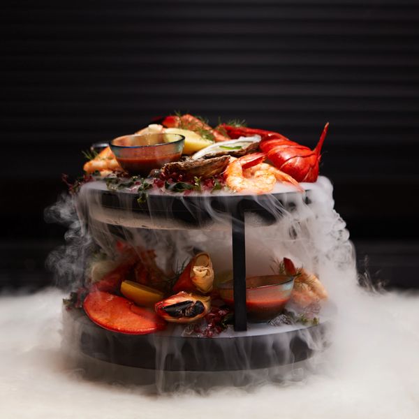 Shellfish tower featuring lobster, shrimp, Alaskan King crab, oysters, and trout dip.