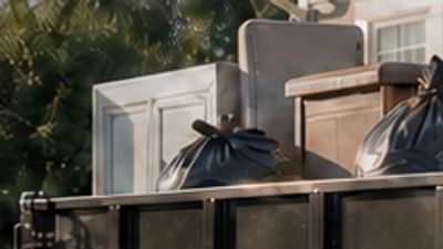 ADC crew loading household items into a dump trailer connected to a pickup truck