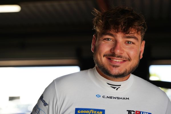 Smiling young man in a racing suit.