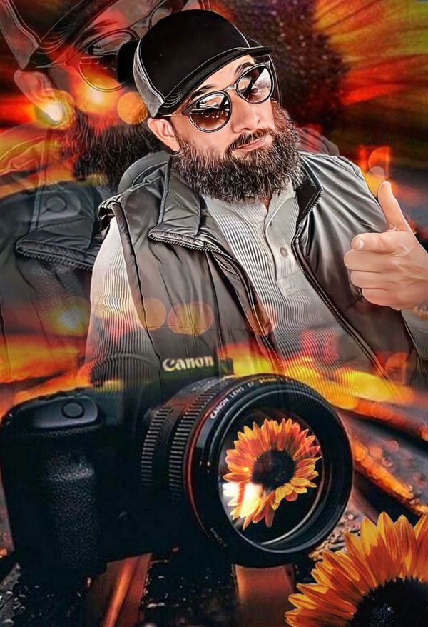 Bearded man with sunglasses and a camera featuring a sunflower reflection.