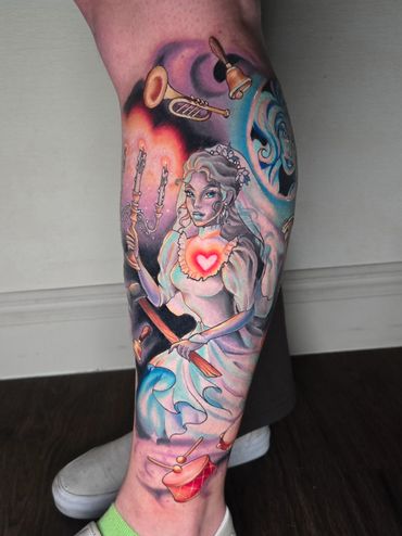 Colorful tattoo of a woman holding a candelabra with musical instruments around.