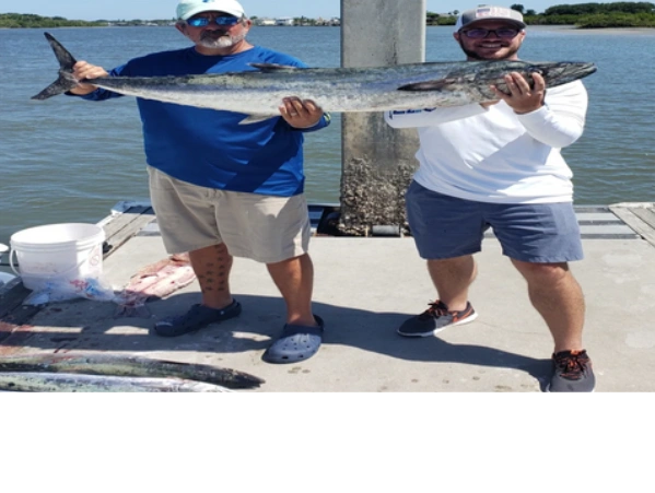 clients holding kingfish they caught while deep sea fishing