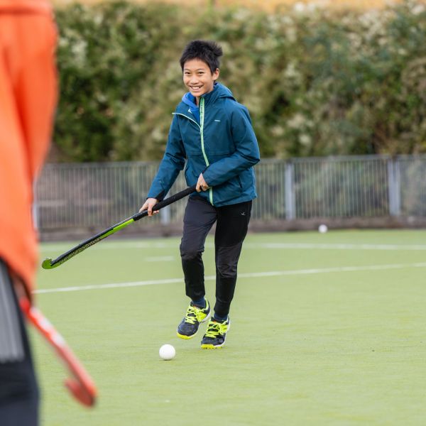 Boy playing field hockey outdoors.