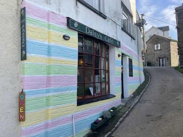 Daisy’s Cafe in Looe with Banjo Cottage in the background
