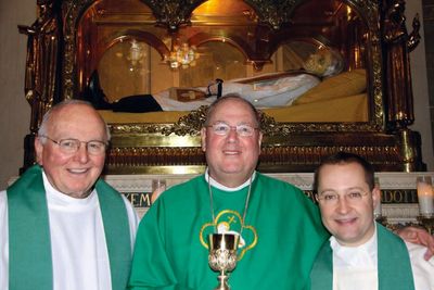 Msgr. Shea, Cardinal Dolan, Fr. Marcello, at the tomb of St. John Vianney in Ars, France.