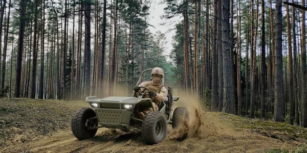Person driving an off-road vehicle through a forest trail.