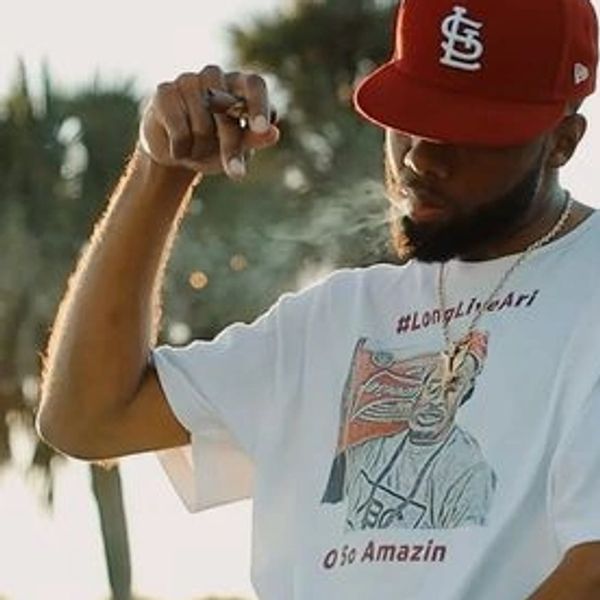 3Fifs wearing St. Louis hat, smoking Escobar Cigar during "Smoke in the Breeze" music video shoot.