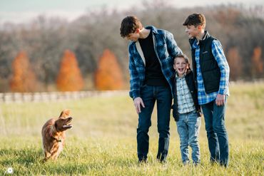 Three boys playing with a dog