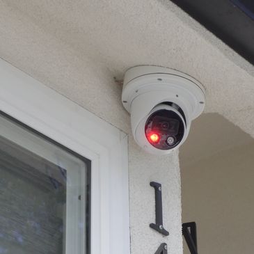 Security camera with red light mounted near house number 146.