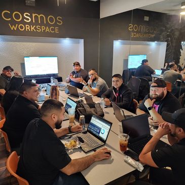 Group of people in a training room working on laptops.