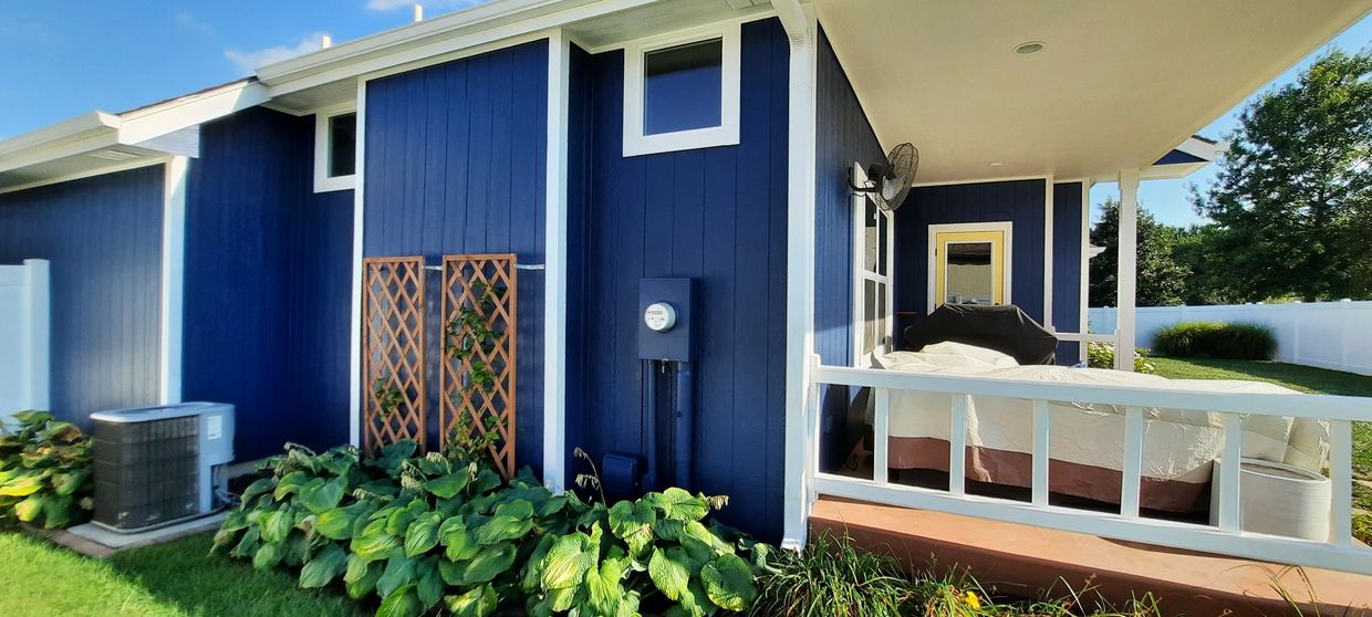 A clean, professionally painted white and blue house in Topeka, Kansas.