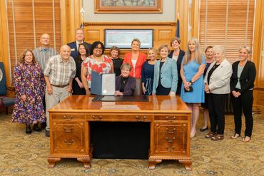 Group of people standing behind a desk.