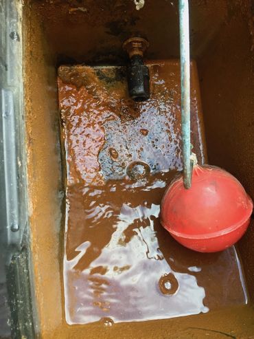 Sludge accumulation in a open vented systems header tank