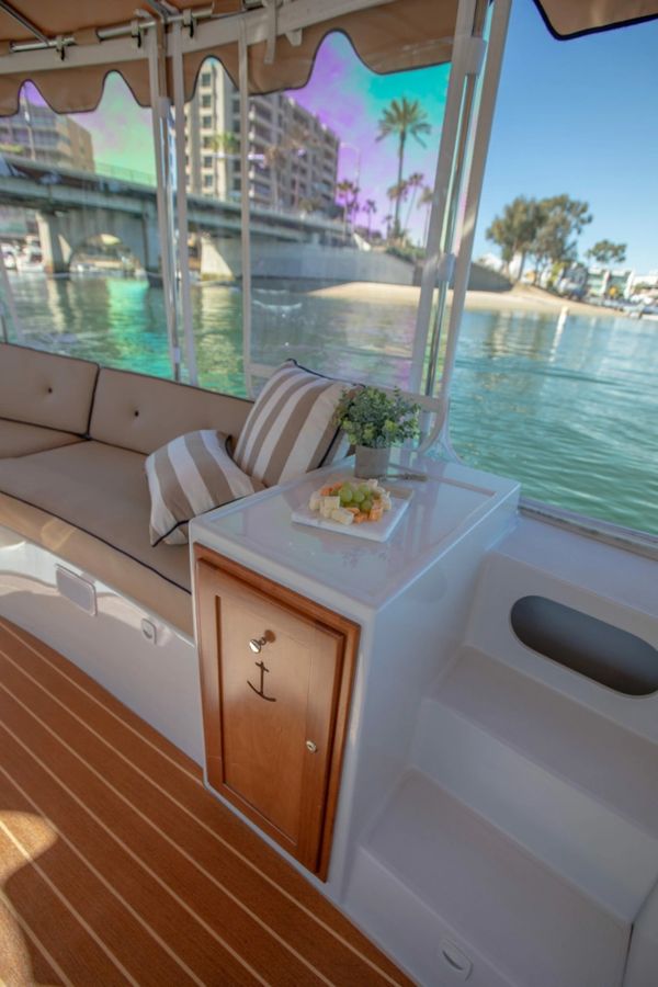Cozy boat seating with a table, snacks, and water view.