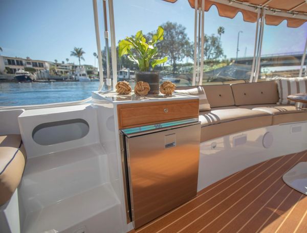 Cozy boat seating area with mini fridge and plant.