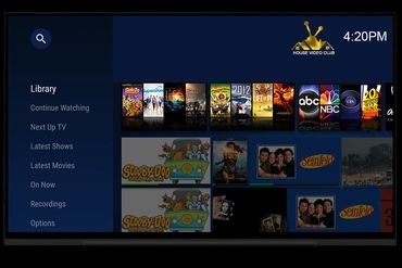 TV interface showing movie and TV show library with various titles and channels.