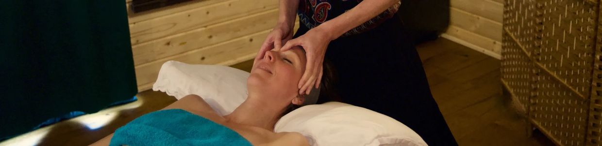 Woman enjoying a relaxing facial massage in a cozy spa room.